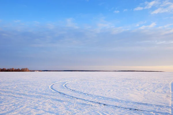 冬日景观白雪覆盖的田野和道路在阳光下的日落 — 图库照片