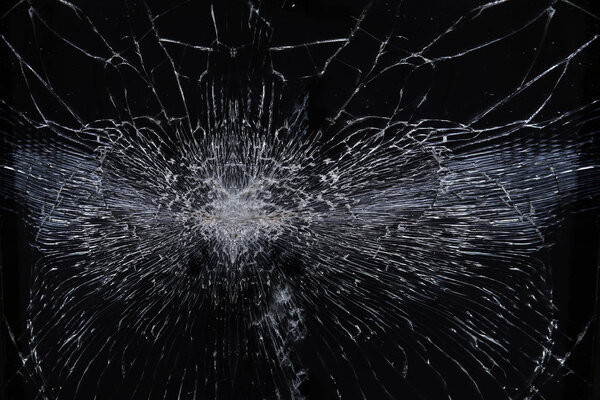 macro texture background broken glass with radial cracks on a black background 