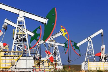 Yazın güneşli bir günde bir tarlada petrol pompalanıyor.