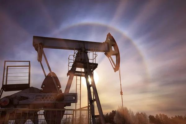 Крупный План Нефтяного Насоса Заснеженном Поле Рядом Лесом Солнечном Ореоле — стоковое фото