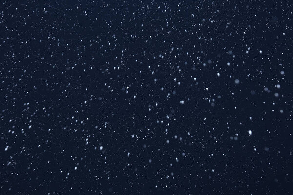 Фон крупным планом текстуры снежинки во время снегопада на синем фоне
