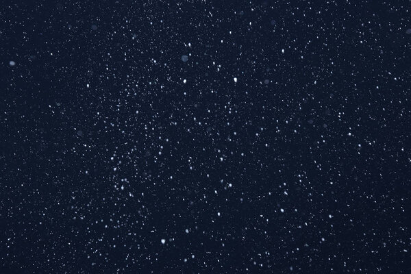 Фон крупным планом текстуры снежинки во время снегопада на синем фоне
