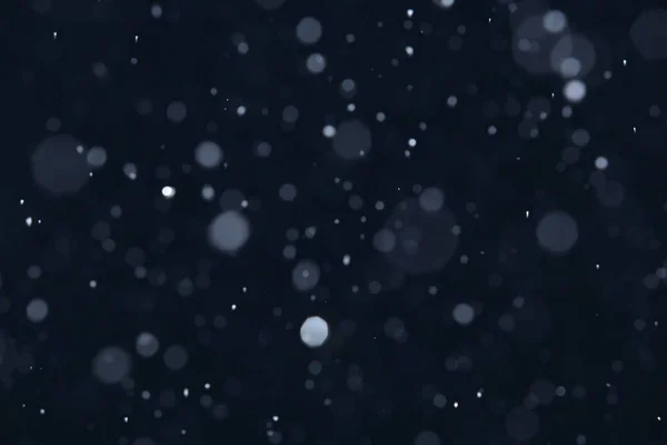 closeup background texture of snowflakes during a snowfall on a blue background