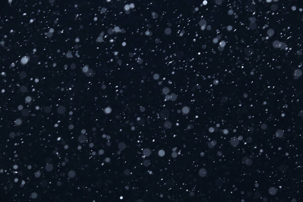 Фон крупным планом текстуры снежинки во время снегопада на синем фоне
