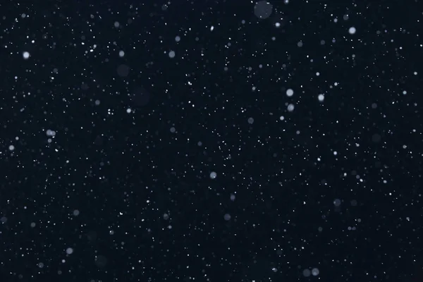 closeup background texture of snowflakes during a snowfall on a blue background