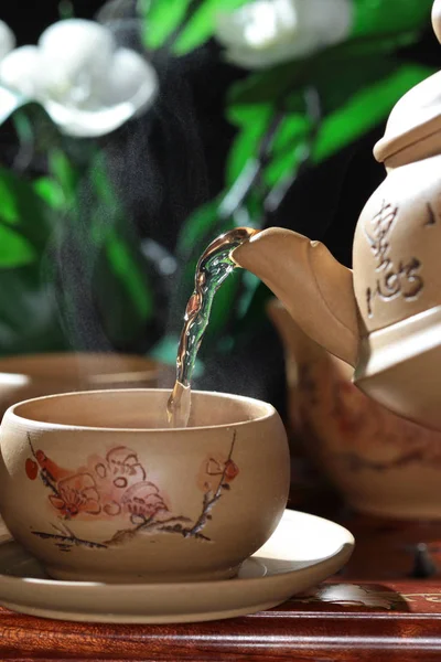 Tee Aus Einer Teekanne Eine Tontasse Auf Einem Verschwommenen Floralen — Stockfoto