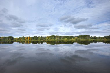 Sonbahar Manzara gündoğumu Nehri ile pürüzsüz bir yüzey ve ağaçlar ve bulutlar su yansıması