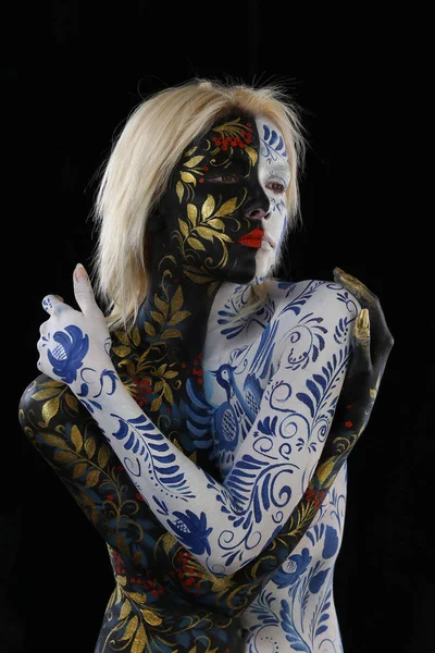 Body art portrait of a girl in the style of Khokhloma and Gzhel on a black background studio