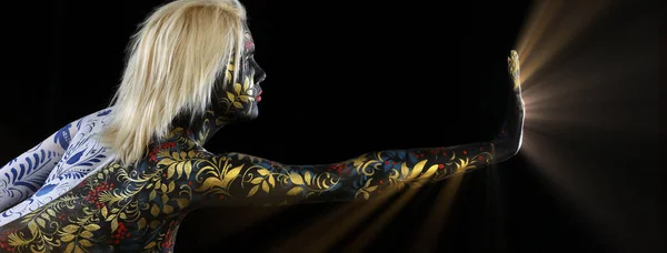 Body art portrait of a girl in the style of Khokhloma and Gzhel on a black background studio