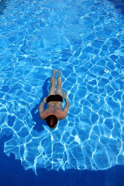 İzole edilmiş gök mavisi su havuzu ve suda yüzücü. 