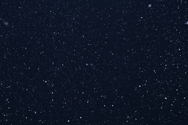 Фон крупным планом текстуры снежинки во время снегопада на синем фоне
