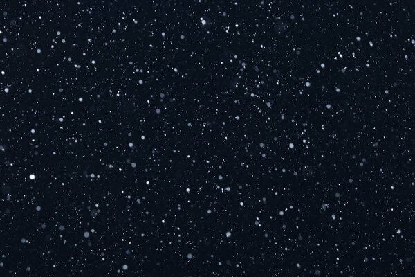 Фон крупным планом текстуры снежинки во время снегопада на синем фоне
