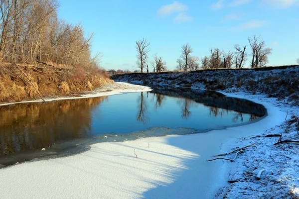 初冬の晴れた日には雪の海岸に葉のない凍る川やオークの木の絵のような風景 — ストック写真