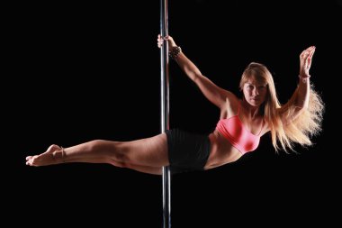 siyah bir arka plan stüdyo pilon üzerinde yapıyor bir genç kadının portresi egzersizleri