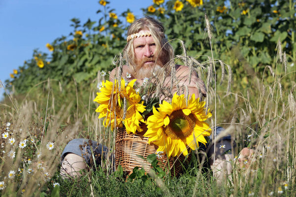 portrait of peasant in a field of sunflowers, get tired from work in summer day