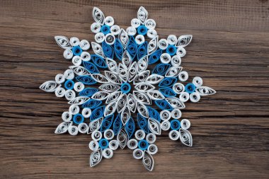 Eski çatlak yönetim kurulu stüdyosunun arka planına karşı kağıttan yapılmış bir kar tanesinin yakın plan çekimi.