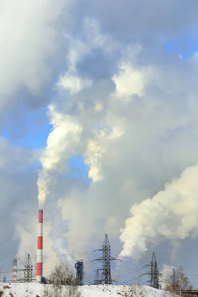 冬の青空に背の高い煙突や送電線から工業用の風景煙が — ストック写真