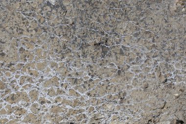 Kışın güneş ışığında çatlayan beton levhanın makro doku parçası.