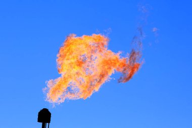 Mavi gökyüzüne karşı yanan bir meşale.