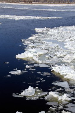 Baharda güneşli bir günde nehir üzerindeki buz tabakası sürükleniyor.