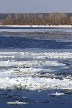 Baharda güneşli bir günde nehir üzerindeki buz tabakası sürükleniyor. 