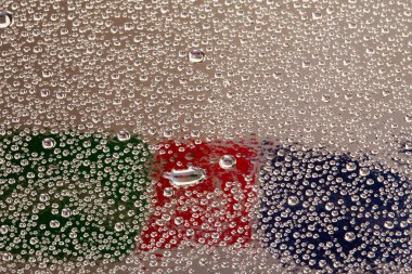 Camdaki su damlacıkları, Rubik Küpü 'nün arka planına yakın çekim.