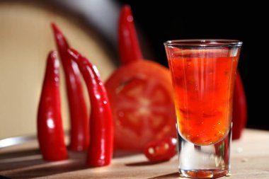 domatesli ve ahşap tahtada acı biberli bir kokteyl.