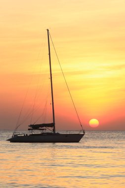 Deniz manzaralı gün batımı ve Tayland kıyılarında sönük yelkenli bir tekne.