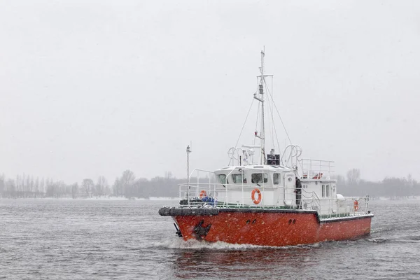 Test the motor boat on the Kama River in the late fall in snowfa