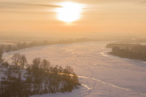 Вид на замерзшую реку и лес на холме зимой — стоковое фото