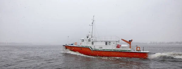 Test the motor boat on the Kama River in the late fall in snowfa