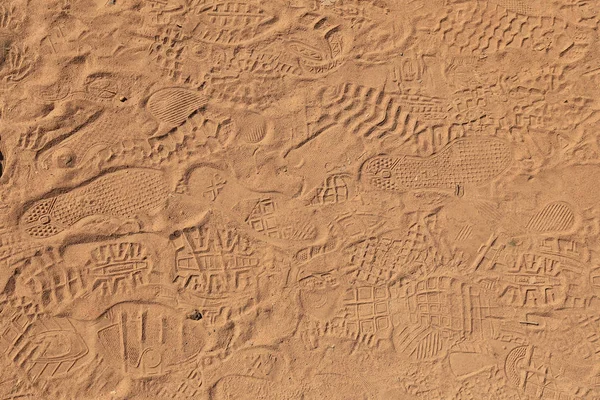 Achtergrond textuur van zand met sporen van schoenen — Stockfoto