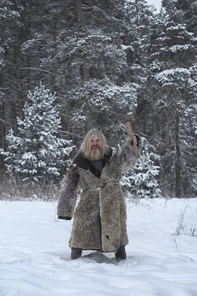 Man met een bijl in het winter forest — Stockfoto