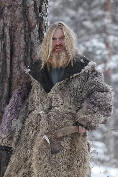 Man met een bijl in het winter forest — Stockfoto