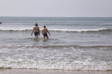 Kuzey Goa, Hindistan - 17 Aralık 2018. İnsanlar bea üzerinde rahatlatıcı