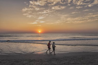Mandrem/Hindistan-Aralık 2018: insanlar gün batımında yürümek, kapalı görmek 