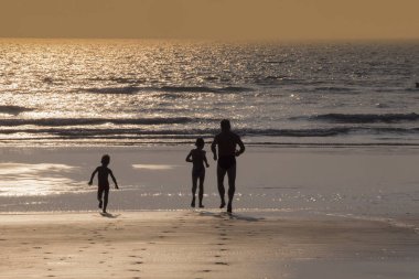 Mandrem/Hindistan-Aralık 2018: insanlar gün batımında yürümek, kapalı görmek 