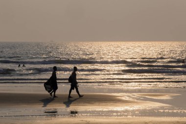 Mandrem/Hindistan-Aralık 2018: insanlar gün batımında yürümek, kapalı görmek 