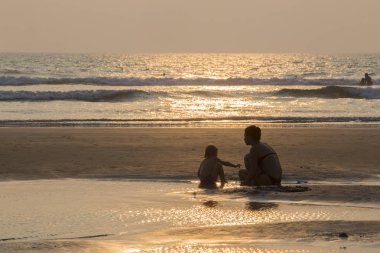 Mandrem/Hindistan-Aralık 2018: insanlar gün batımında yürümek, kapalı görmek 