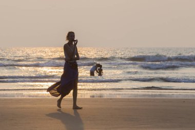 Mandrem/Hindistan-Aralık 2018: insanlar gün batımında yürümek, kapalı görmek 