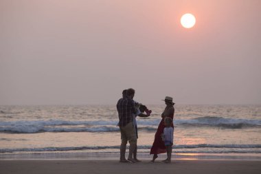 Mandrem/Hindistan-Aralık 2018: insanlar gün batımında yürümek, kapalı görmek 