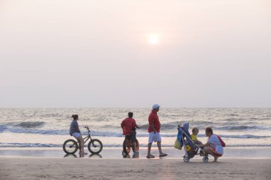 Mandrem/Hindistan-Aralık 2018: insanlar gün batımında yürümek, kapalı görmek 