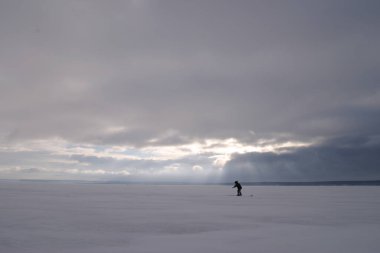 Kış manzarası balıkçıları gün batımında Eek nehrinde balık tutuyor.
