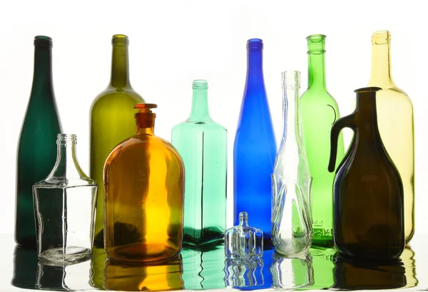 Крупним Планом Чисті Прозорі Скляні Пляшки Різних Форм Дзеркальній Поверхні — стокове фото