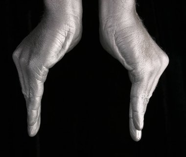 İnsan elinin yakın çekimi siyah arka planda bir kase ya da çiçek çeşidini temsil eder.