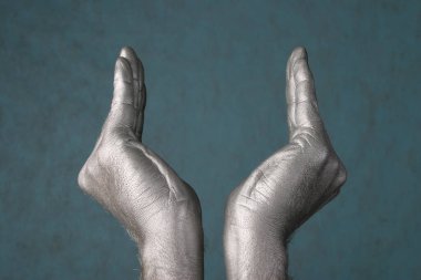 İnsan elinin yakın çekimi, mavi-gri arka planda bir tür kase ya da çiçeği temsil eder.