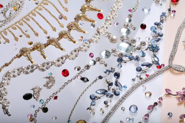 Makro zarif çeşitli mücevherler, kolyeler ve küpeler. Beyaz arka plan stüdyosunda renkli taşlar.