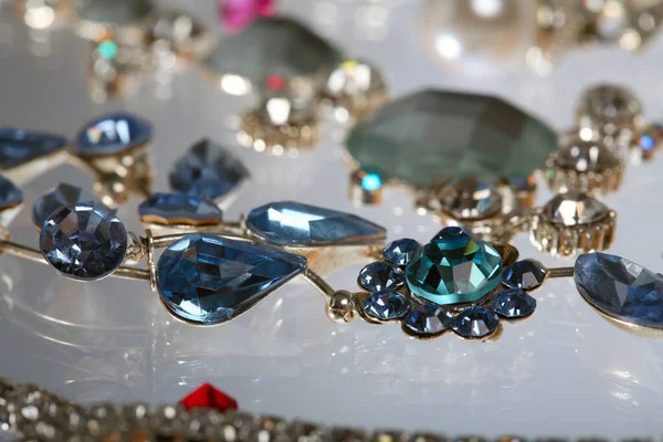 Makro zarif çeşitli mücevherler, kolyeler ve küpeler. Beyaz arka plan stüdyosunda renkli taşlar.