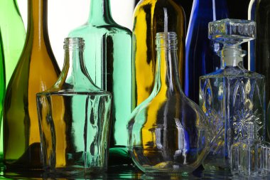 Beyaz stüdyo arka planında güzel renkli boş şişelerin izole edilmiş yakın çekim koleksiyonu.