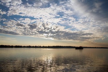 güzel yaz manzarası güzel gün batımı nehir üzerinde, güzel bulutlar ve ağaçlar kıyıda.